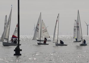 Under bright sunshine the boats hover around the start line