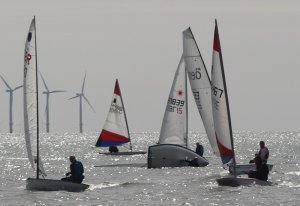 A sudden breeze catches Andy Stafford out, who capsizes his Laser amongst the fleet