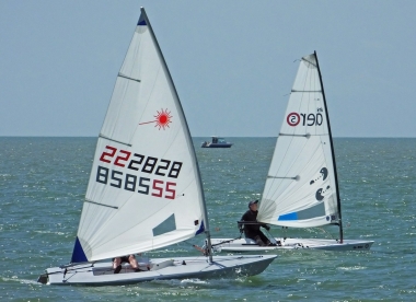 Paul Stanton, in his Laser, and Derroll Pedder in his RS Aero stay close to the shore