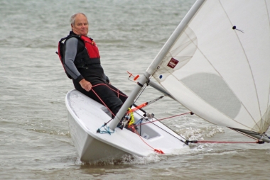 Paul Stanton is caught out by the gust and, shortly after, capsized in his Laser