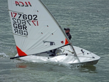 Leading for much of the race; Adam Kedge finishes second in his Laser