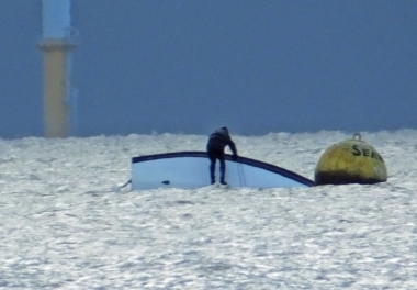 Simon Kedge capsizes his Laser offshore by the Seaward buoy