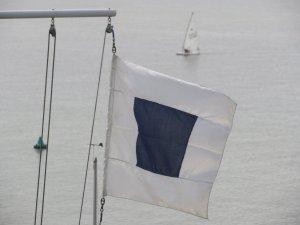 The shorten course flag gently flies as Robert Mitchell sails towards the finish line.....
