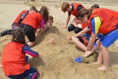 Building a sandcastle in the shape of a woman