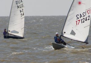 Clare Giles in her Europe, and Yvonne Gough in her Laser, driving their boats to the next mark