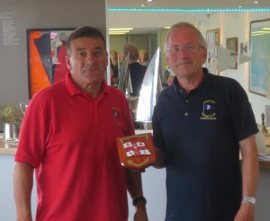 Ken Potts (left) receives the RNLI Charity Shield from Commodore Richard Walker