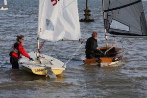 Beth Ford about to step aboard her Laser as Michael Gutteridge heads off in his Solo on Wednesday evening