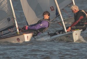 Clare Giles, in her Europe, holds off Andy Dunnett in his Laser
