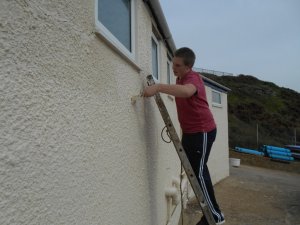 Cadet Michael "splashes it on" repainting the outside of the changing rooms