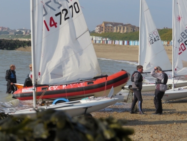 Rob Lockett launches his Laser whilst the race winner - Ken Potts has a few words to say to a fellow competitor