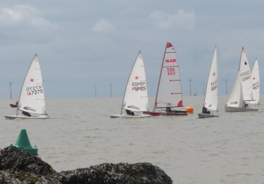 On a close start line, Ken Potts leads the fleet away in his Laser