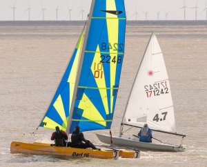 Rob Mitchell and Brian Allen, in their Dart 16, fly past Yvonne Gough in her Laser 4.7