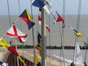 Jono and Gregg Dunnett flying towards the beach, framed by the Jubilee celebration flags