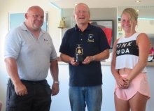 Commodore Richard Walker presents Dave Fowell and Amy Hart with the Bell Trophy for the GP14 class after some fine tactical racing