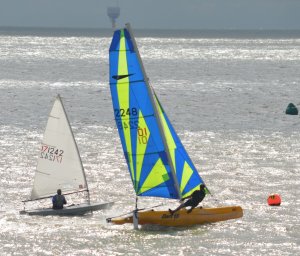 Robert Mitchell's Dart 16 dwarfs Yvonne Gough, in her Laser, as he sails towards victory