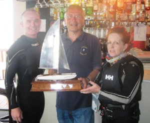 Commodore Richard Walker presents the David Foster Catamaran Challenge Trophy to Pete Boxer and Eilish Dempsey