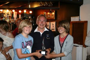Charlie and Harry Spence are presented with the Amazon Trophy by Club Commodore Richard Walker