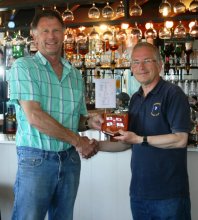Robert Mitchell receives the trophy from Commodore Richard Walker for winning the RNLI Charity Shield Race
