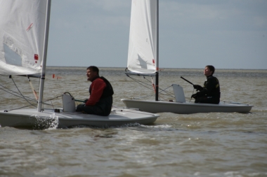 Ken Potts holding back Robert Gutteridge in the Laser fleet; going on to win the race