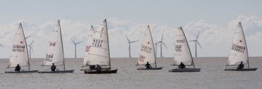 The fleet gets underway with the windfarm looking on